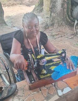 A female tailoring trainee sat at her sewing machine